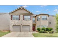 Charming two-story home featuring a brick facade, two-car garage, and well-maintained landscaping at 556 Emporia Loop, Mcdonough, GA 30253
