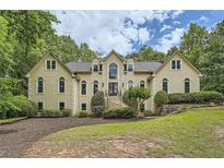 Stately home with mature trees, manicured lawn, and grand entrance staircase at 5940 Plantation Dr, Roswell, GA 30075