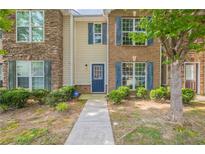 Charming townhome with brick and siding exterior, featuring blue shutters and a well-maintained front yard at 1851 Grove Way, Hampton, GA 30228