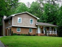 Charming two-story home with a brick and wood facade and a welcoming front porch at 2592 King Louis Ne Rd, Conyers, GA 30012