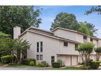 A charming townhouse featuring neutral siding, attached garages, and a well-manicured lawn with mature trees at 4096 Audubon Dr, Marietta, GA 30068