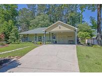 Charming one-story home with a welcoming front porch and a spacious driveway leading to a covered carport at 530 Chicapoo Dr, Marietta, GA 30066