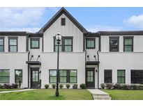 Charming townhome showcasing a painted brick facade, black framed windows, and manicured lawn at 2406 Lakeshore Ln, Atlanta, GA 30316