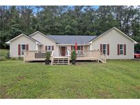 Charming single-story home featuring a spacious front yard and a welcoming wooden deck with access to the front door at 4746 Mulberry Rock Rd, Dallas, GA 30157