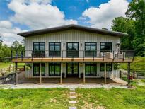 Striking two-story home featuring a spacious deck with modern railings, perfect for outdoor entertaining at 1971 Centennial Rd, Rutledge, GA 30663