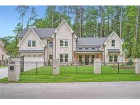 Stunning brick home with black iron fence and manicured lawn, surrounded by mature trees at 2625 Beverly Ln, Snellville, GA 30078