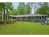 Charming home backyard featuring a well-maintained lawn, patio seating, and colorful flower boxes at 2762 Whispering Pines Dr, Decatur, GA 30033