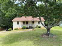Charming single-story home with a well-manicured lawn and mature trees at 285 Woodland St, Dallas, GA 30157