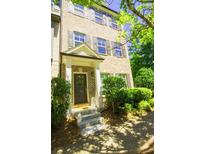 Charming brick townhouse with a covered front door entrance and well-manicured landscaping at 1420 Baygreen Rd, Suwanee, GA 30024