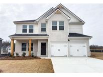 Charming two-story home with painted white brick, a two-car garage, and manicured front yard at 190 Orwell Dr, Social Circle, GA 30025