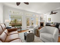 Bright living room featuring large windows, neutral colors, and a cozy fireplace perfect for relaxing at 220 Riverview Trl, Roswell, GA 30075