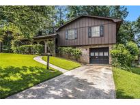 Charming split-level home with well-maintained lawn, brick accents, and an attached garage at 2209 Willoby Ct, Morrow, GA 30260