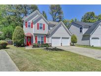 Charming two-story home with a well-manicured lawn, red door, red shutters, and attached two-car garage at 2477 Lakebrooke Dr, Marietta, GA 30066
