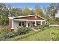 Charming craftsman style home with inviting front porch, beautiful landscaping and mature trees at 4442 Mclain Cir, Acworth, GA 30101