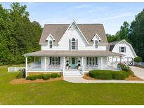 Charming two-story white home with a welcoming front porch and well-manicured landscaping at 692 Brooks Woolsey Rd, Brooks, GA 30205