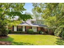 Charming brick home with a well-manicured lawn and mature trees providing shade at 186 Mt Calvary Rd, Marietta, GA 30064