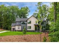 Beautiful new construction with three-car garage, board and batten siding, professional landscaping, and mature trees at 130 Nova Ln, Roswell, GA 30075
