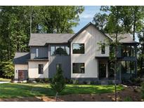 Modern two-story home with a combination of light and dark siding and well-maintained lawn at 130 Nova Ln, Roswell, GA 30075