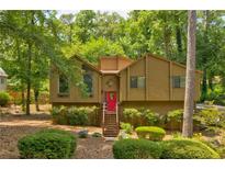Charming, multi-level home with natural landscaping, a red door and surrounded by mature trees at 317 Hoofbeat Ne Trl, Kennesaw, GA 30144