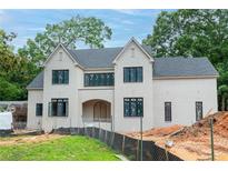 Newly built, a stunning two-story home features a light brick exterior, black-framed windows, and a charming arched entryway at 4608 Kings Down Rd, Atlanta, GA 30338