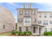Charming brick townhome featuring a covered entryway, detailed trim, and well-maintained landscaping at 2252 Talmai Dr, Snellville, GA 30078