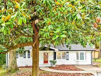 Charming white brick home featuring a well-manicured lawn, inviting walkway, and mature magnolia tree at 4808 Oak Ct, Ellenwood, GA 30294