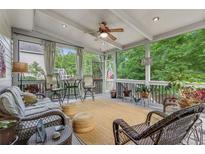 Cozy screened porch with wicker furniture, ceiling fan and views of the lush green backyard at 2073 Woodside Park Dr, Woodstock, GA 30188