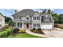 Charming two-story home with gray siding, black shutters, a red door and a well-manicured lawn at 224 Mountain View Dr, Woodstock, GA 30188