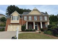Charming two-story brick home with a well-manicured lawn and inviting front porch at 5865 Trailwood Ct, Suwanee, GA 30024