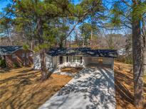 Charming single-story home boasts a covered carport, long driveway, and fresh landscaping at 1890 Carla Dr, Morrow, GA 30260