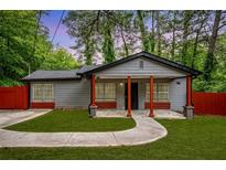 Charming single-story home with gray siding, red accents, covered porch and well manicured lawn at 3479 Thompson Dr, Atlanta, GA 30331