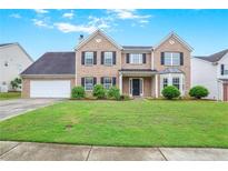 Charming two-story brick home with a well-manicured lawn and classic black shutters at 841 Holly Meadow Dr, Buford, GA 30518