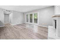Bright living room featuring hardwood floors, fireplace and door to balcony with view at 113 Tuxworth Cir, Decatur, GA 30033
