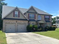 Beautiful brick two-story home featuring a two-car garage, manicured lawn, and traditional architectural details at 4482 Ridge Mill Ne Ter, Douglasville, GA 30135