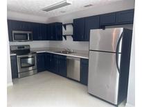 Galley kitchen with stainless steel appliances and blue cabinets offering style and functionality at 5425 Village Green Sq, Norcross, GA 30093
