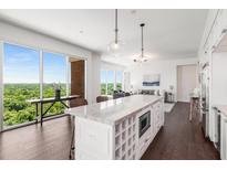 Bright kitchen with large island, pendant lighting, and scenic views through expansive windows at 1820 Peachtree St # 1607, Atlanta, GA 30309