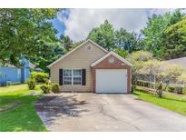 Charming single Gathering home featuring a single car garage, brick accent, and beautifully manicured lawn at 1321 Waterton Trl, Douglasville, GA 30134