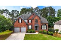 Charming brick two-story home with a manicured lawn and two-car garage, nestled among lush trees at 4963 Kingsbridge Ct, Powder Springs, GA 30127