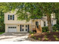 Charming split-level home with a well-manicured lawn, blue shutters, and an attached garage at 5999 Brookside Se Ln, Mableton, GA 30126