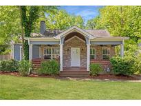 Charming brick home with a cozy front porch, lush lawn, and mature trees in a quiet neighborhood at 1364 Westboro Sw Dr, Atlanta, GA 30310