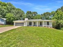 Charming single-story home with a well-manicured lawn, attached garage, and inviting front porch at 2492 Wild Rose Cir, Lawrenceville, GA 30044