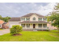 Charming two-story home with a large, inviting front porch and a well-maintained lawn at 5696 Glandor Dr, Mableton, GA 30126