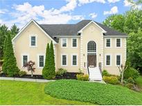 Charming two-story stucco home with a manicured lawn, mature trees, and inviting entrance at 789 Rutland Ct, Lithonia, GA 30058