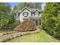 Charming two-story home featuring mature landscaping, a brick walkway, and a covered front porch at 2190 Stephen Long Ne Dr, Atlanta, GA 30305