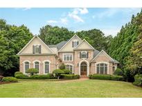 Elegant brick home with manicured lawn and lush landscaping, offering curb appeal at 314 Caruso Ct, Sandy Springs, GA 30350