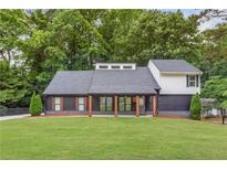 Charming home featuring a modern design with a covered porch and a well-manicured front yard at 347 Chip Rd, Stone Mountain, GA 30087