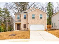 Charming two-story brick home featuring a two-car garage and a well-manicured front yard at 4700 Blake Loop, Atlanta, GA 30349