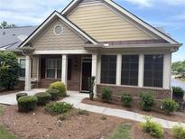 Charming home with brick and siding, a well-manicured lawn and walkway leading to the front door at 1585 Oak Meadows Ln, Cumming, GA 30041