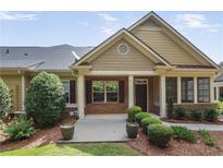 Charming single-story home showcasing a landscaped front yard, brick accents, and a welcoming front porch at 1585 Oak Meadows Ln, Cumming, GA 30041
