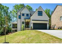 Charming two-story home with a black two-car garage door and a well-manicured lawn at 2235 Birchtree Way, Marietta, GA 30062
